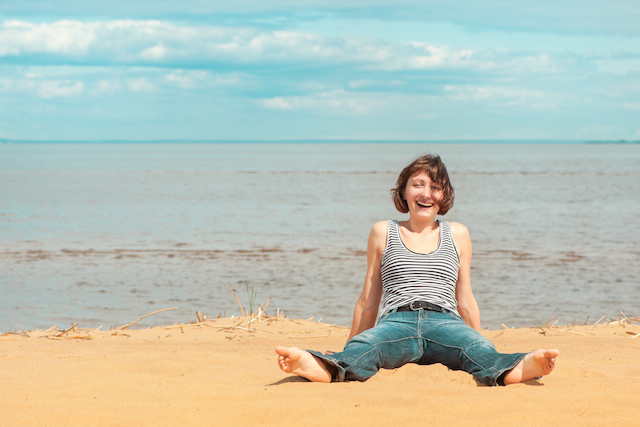 Happy woman sitting on the beach